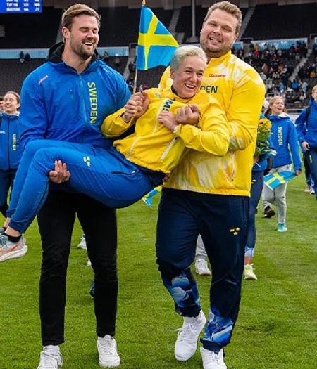 Simon Pettersson och Daniel Ståhl på väg att kasta förbundskapten Kajsa Bergqvist i vattengraven.
