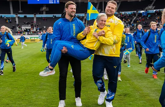 Simon Pettersson och Daniel Ståhl på väg att kasta förbundskapten Kajsa Bergqvist i vattengraven.